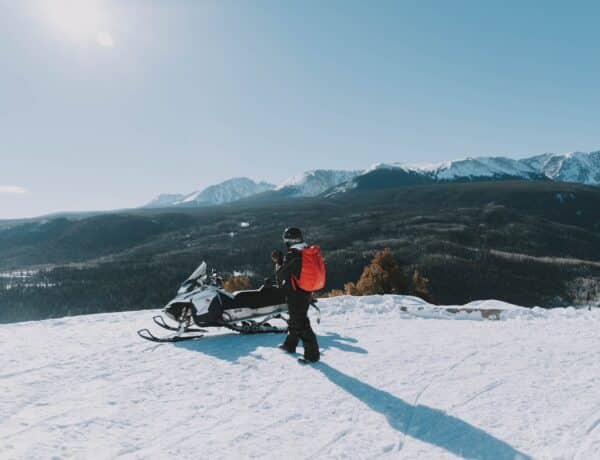 Man Walking Near the White and Black Snowmobile - Nate Johnston - From Unsplash