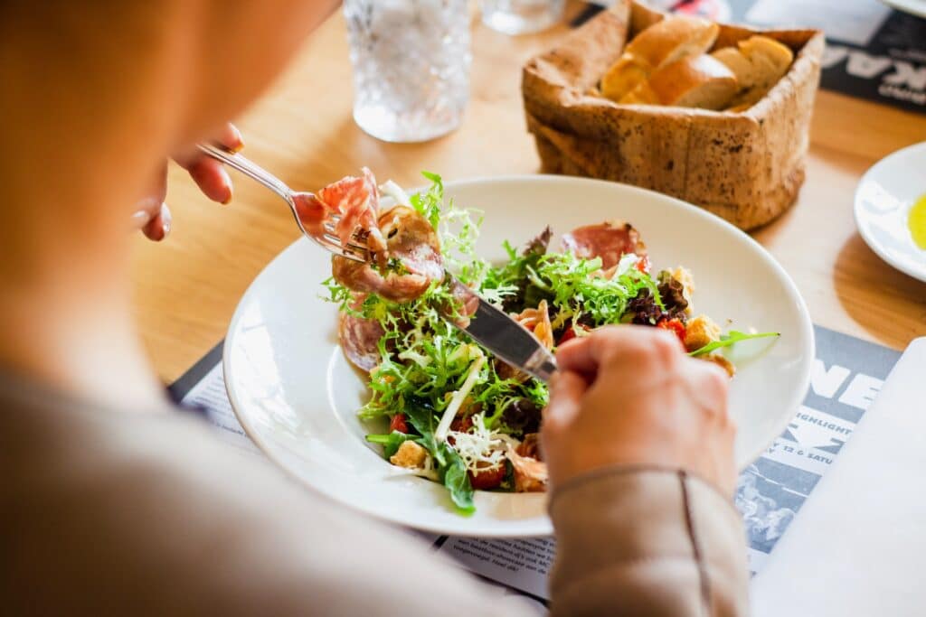 Person Eating Salad - in a Restaurant - in Bas-Saint-Laurent - Louis Hansel From Unsplash