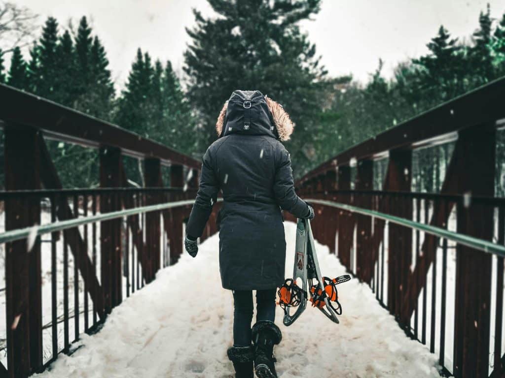 Woman on bridge with snowshoes - Pexels -Lure of Adventure