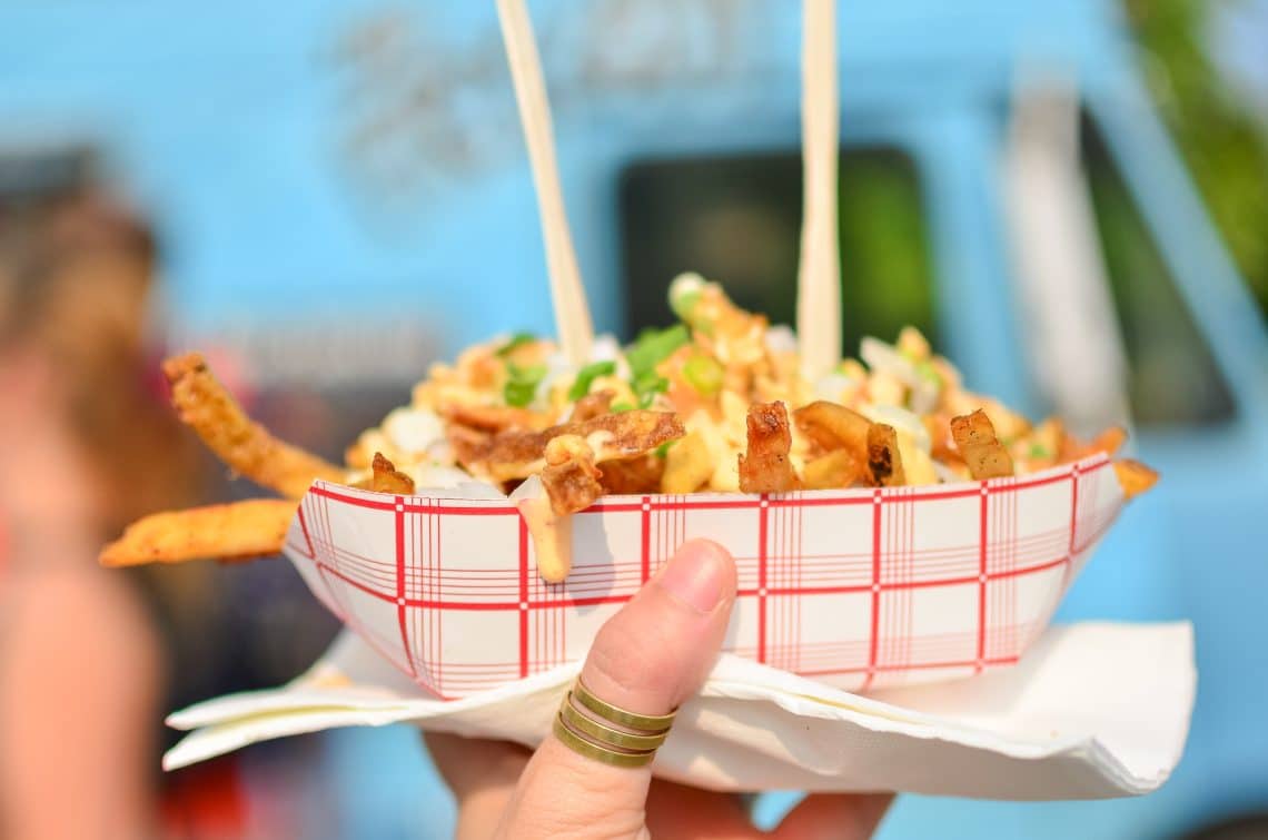 Loaded frieds being help up in front of a food truck - Photo: Ayesirally